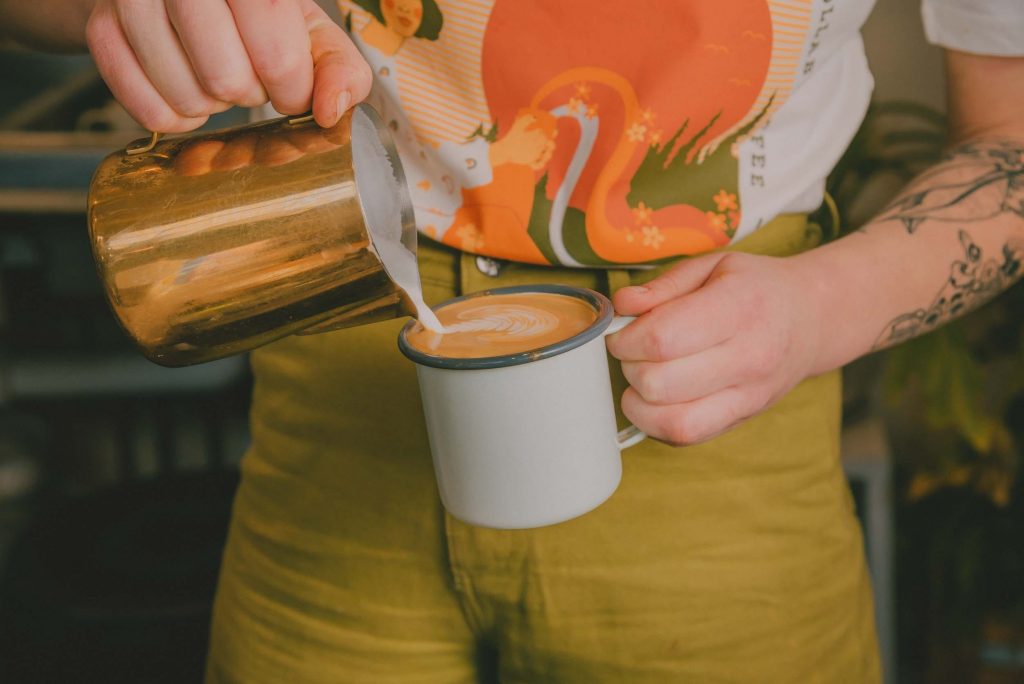 Our expert barista pouring latte art on a cup of specialty coffee at Camp Grounds Tamworth Coffee Sh